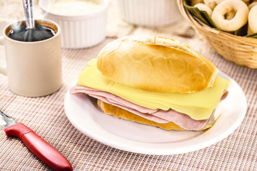 Pão francês com queijo e presunto café da manhã com café quente e biscoitos