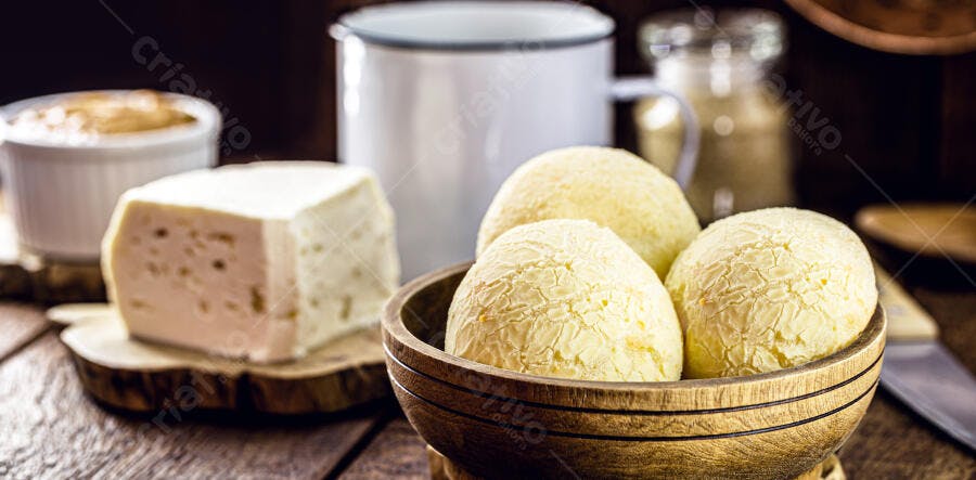 Pão de queijo fresco com queijo minas e café no café da manhã rústico
