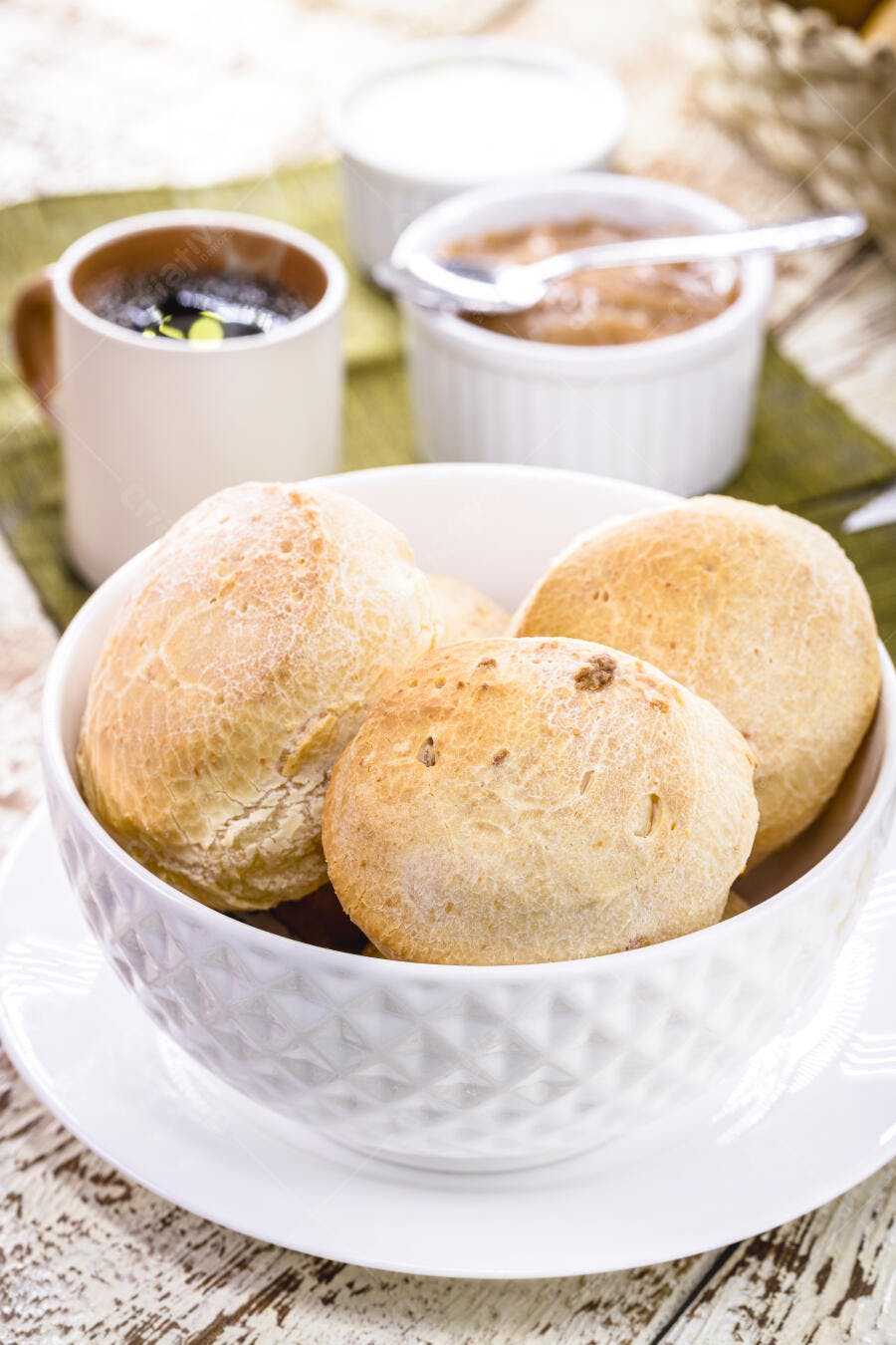 Pão de queijo fresco em tigela branca com café para café da manhã aconchegante