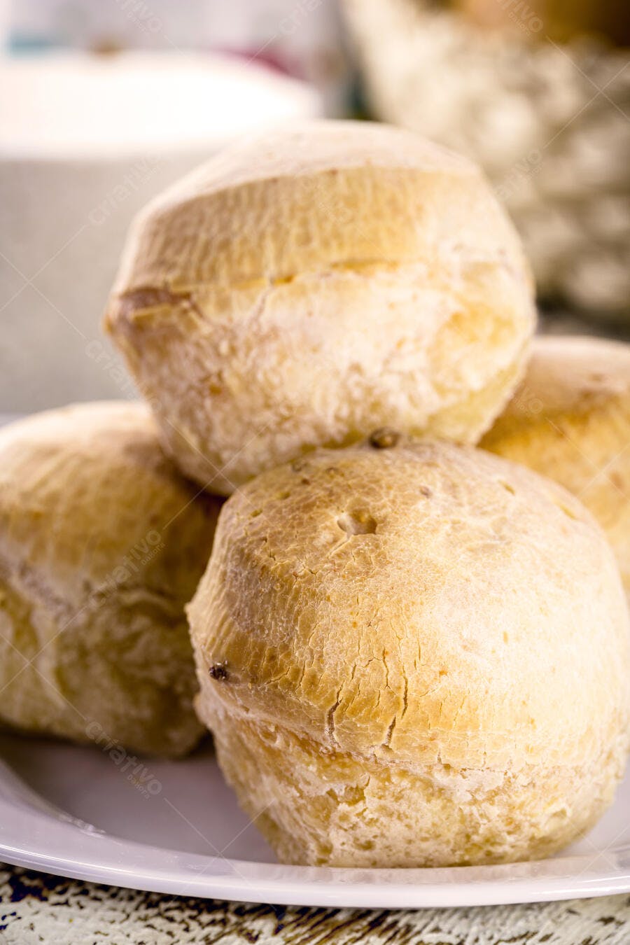 Pães de queijo dourados e fresquinhos em prato branco para café da manhã