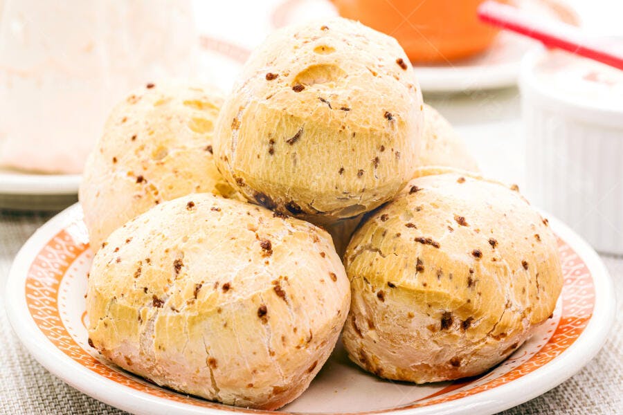 Pães de queijo dourados em prato decorado para café da manhã ou lanche