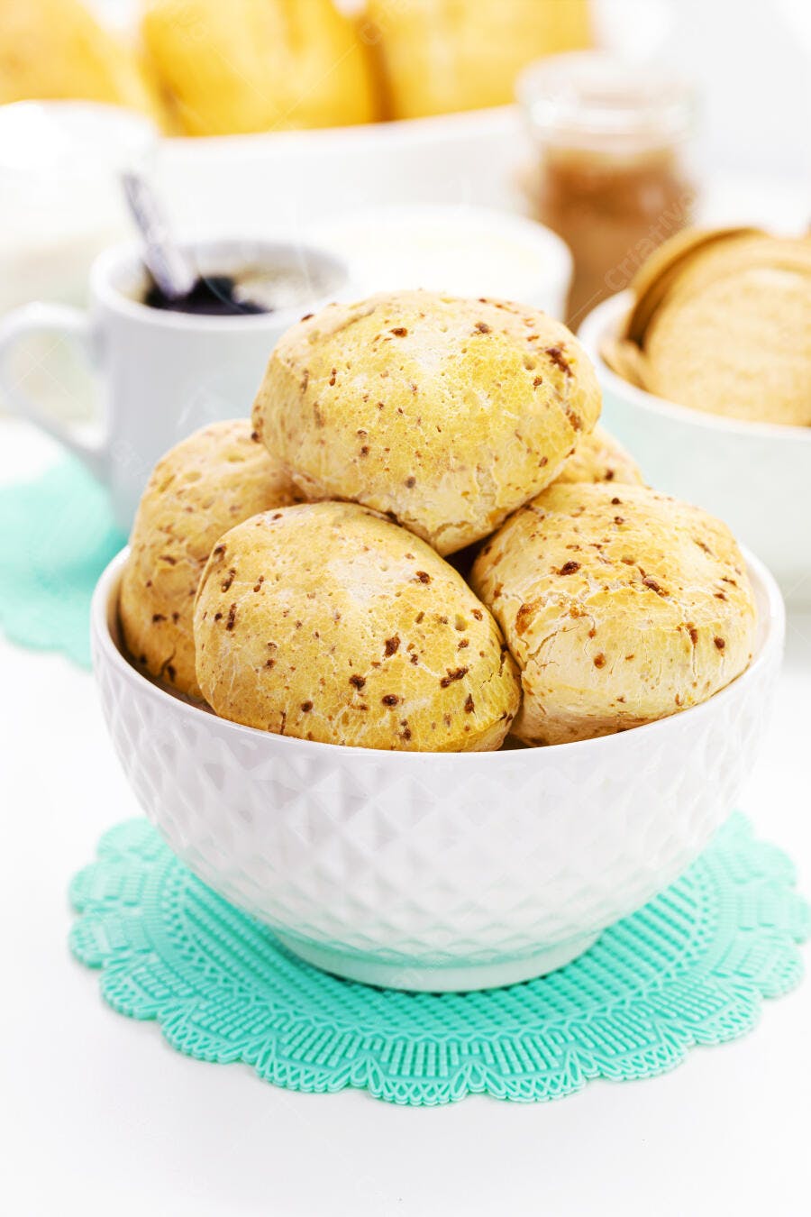 Pães de queijo amarelos dourados em tigela branca para um café da manhã aconchegante