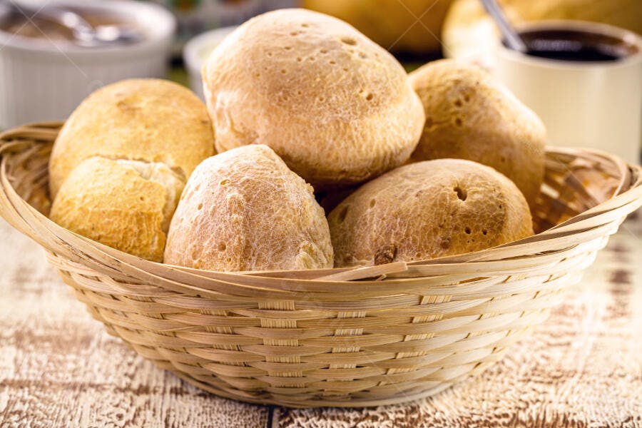Pães de queijo frescos em cesta de vime para café da manhã