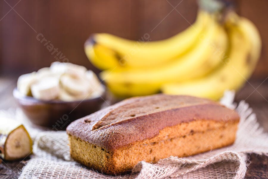 Bolo de banana caseiro com bananas frescas e fatias em tigela de madeira
