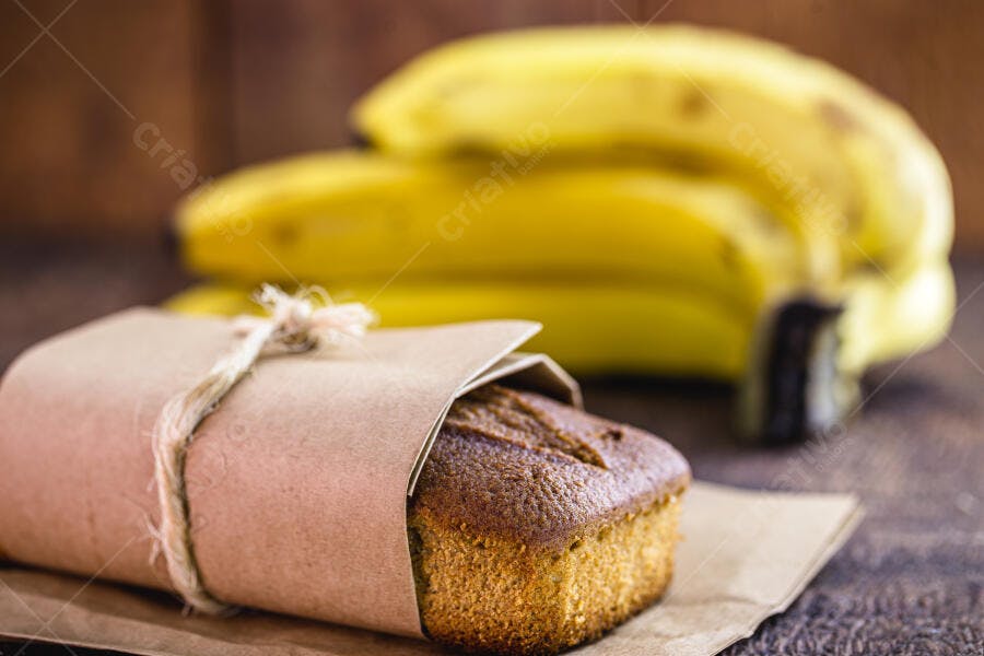 Bolo de banana caseiro embrulhado em papel craft com bananas frescas