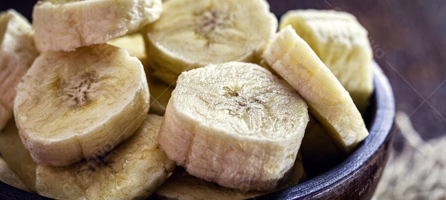 Banana fatiada fresca em tigela de madeira close-up