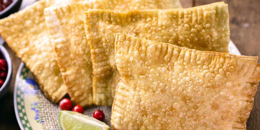 Pastéis dourados e crocantes com limão e frutas vermelhas em prato