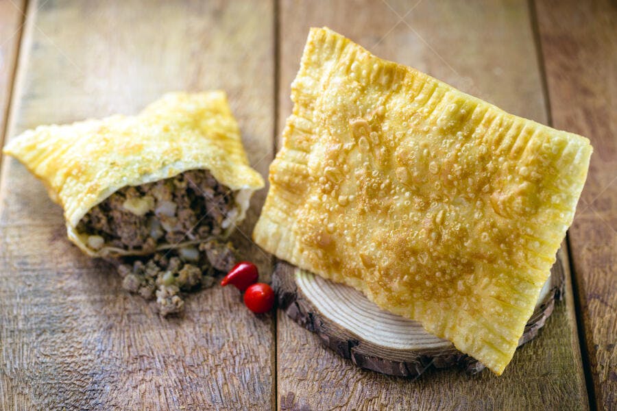 Pastel crocante de carne com pimenta na mesa de madeira rústica