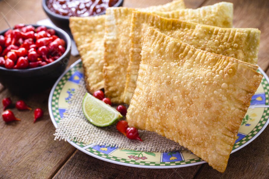 Pastéis fritos dourados com pimenta biquinho e limão fresco