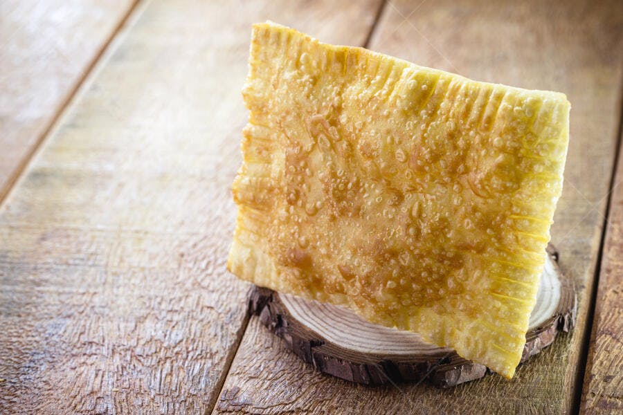 Pastel brasileiro frito dourado em madeira rústica clara
