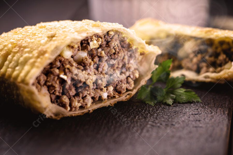 Pastel de carne frito dourado com recheio suculento e salsinha fresca