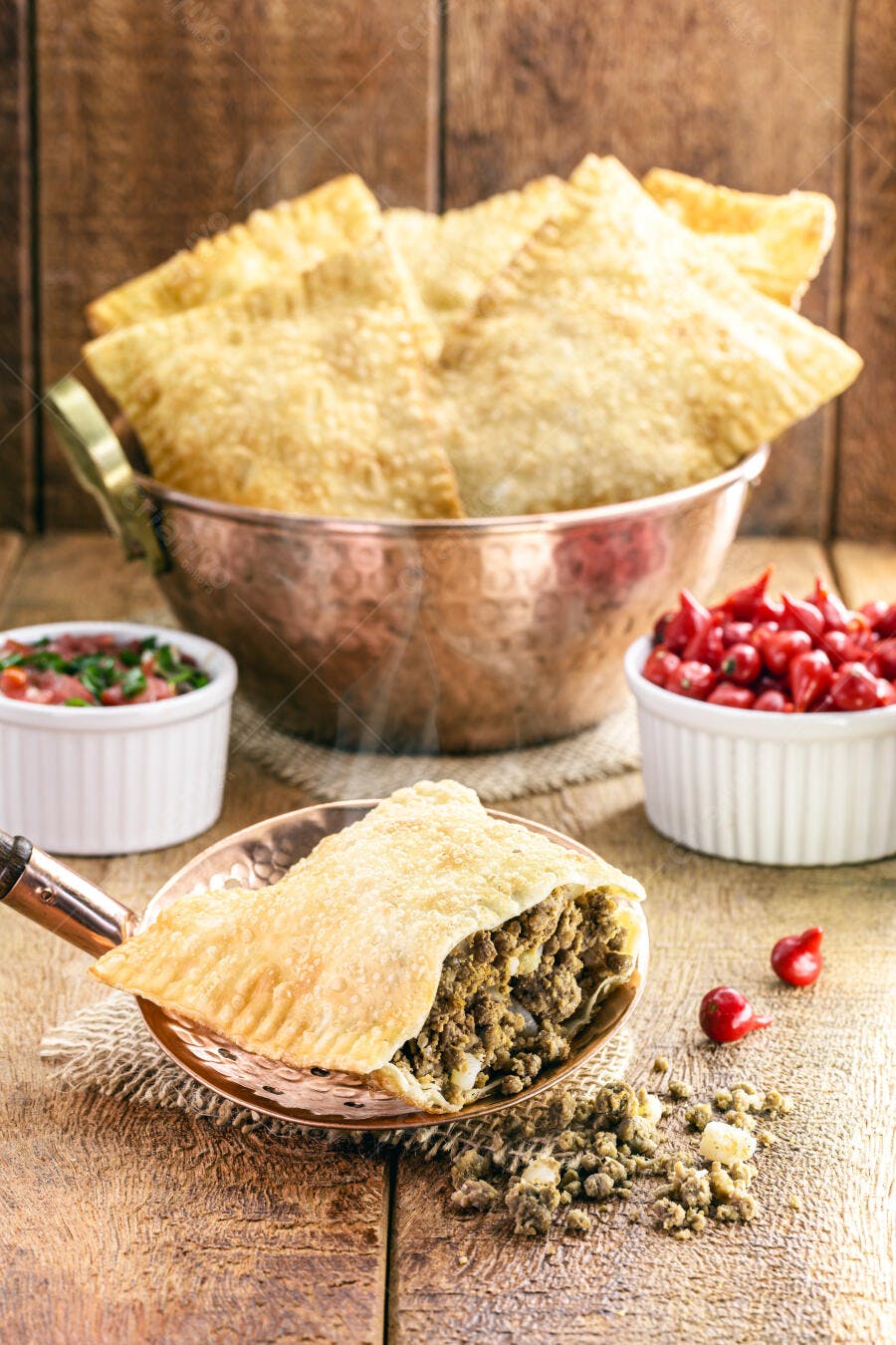 Pastel de carne frito com pimenta e vinagrete em madeira rústica