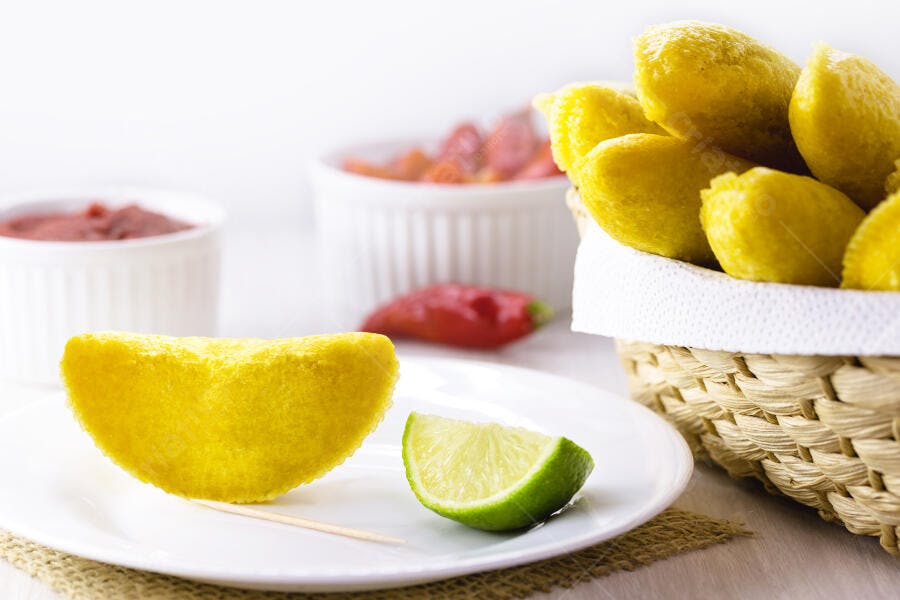 Pastel frito dourado com limão fresco e molhos com pimentão