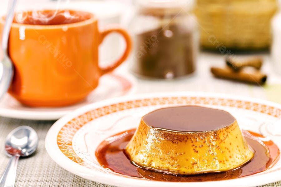 Pudim de leite dourado com calda de caramelo e café na mesa de café da manhã