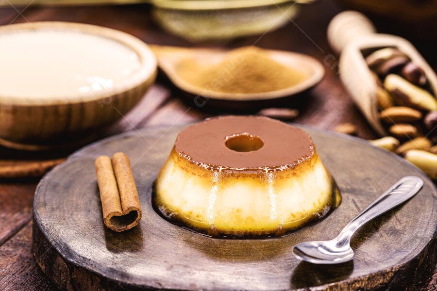 Pudim de leite condensado tradicional com canela e caramelo em tábua de madeira