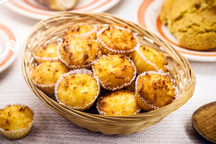 Bolinhos de coco dourados em cesta de vime tradicional brasileira