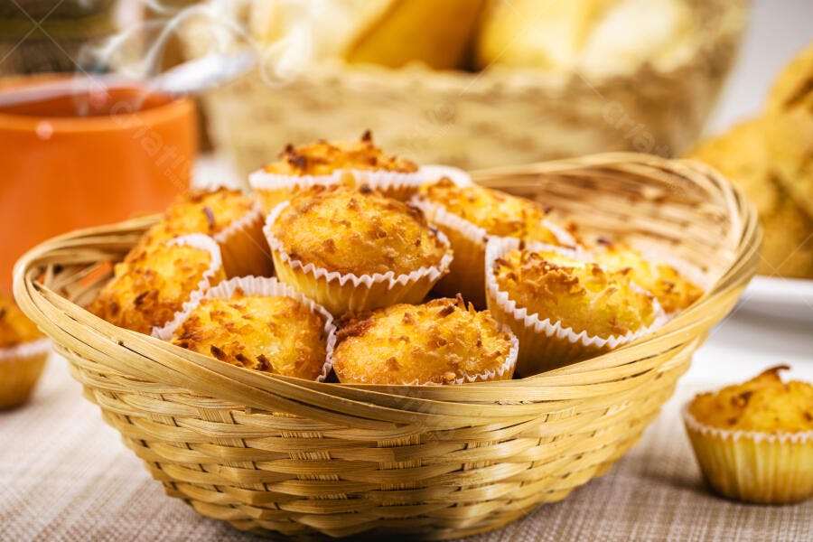 Cesta de vime com pequenas cocadas douradas assadas para café da manhã ou lanche