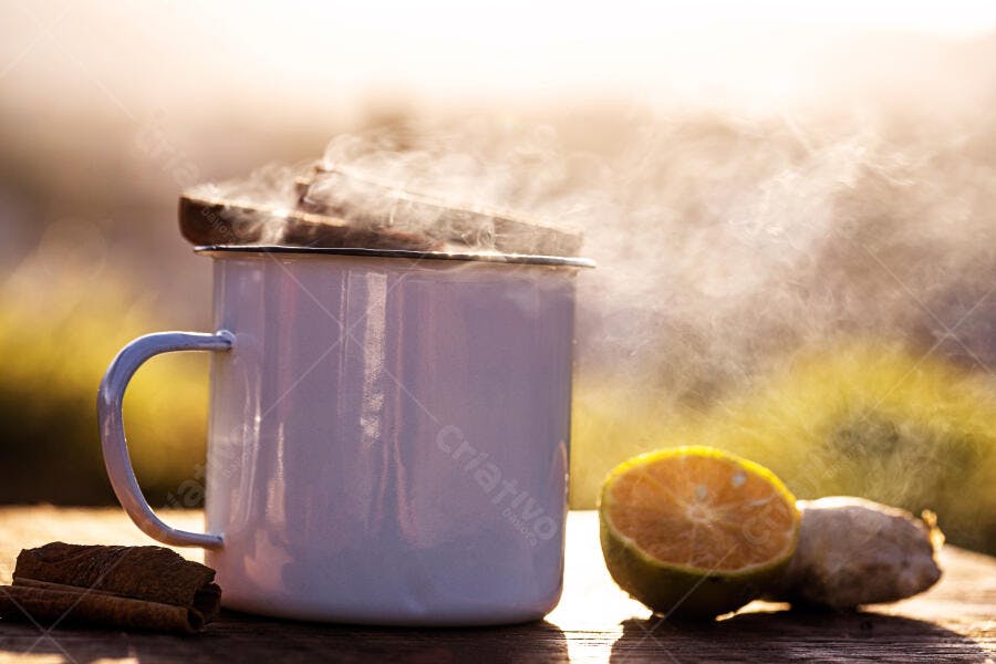 Caneca branca com vapor especiarias canela gengibre laranja em mesa de madeira rústica