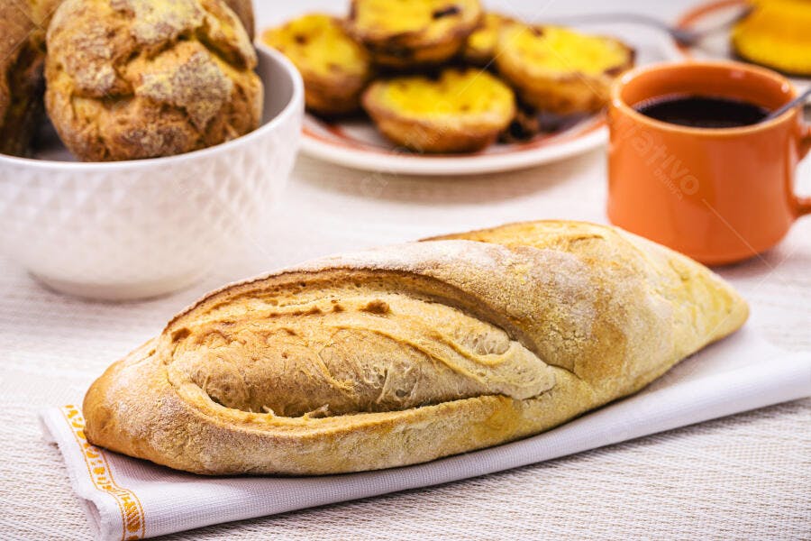 Pão rústico fresco com pastéis de nata e café para o café da manhã
