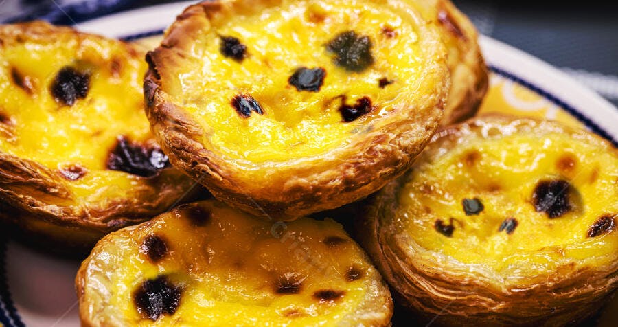 Pastéis de Nata portugueses frescos com crosta crocante em prato