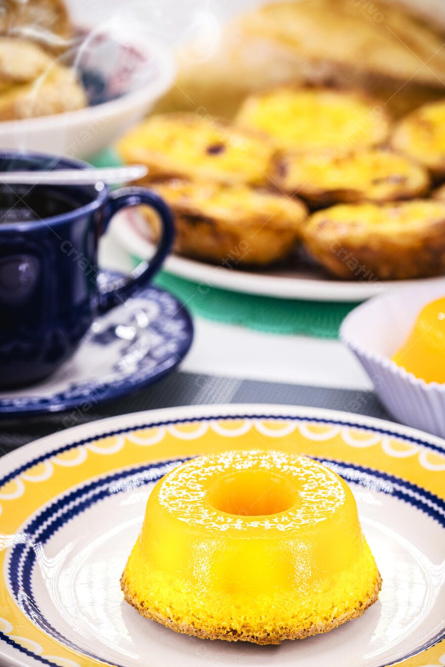 Pudim de maracujá amarelo em prato com café e doces de confeitaria
