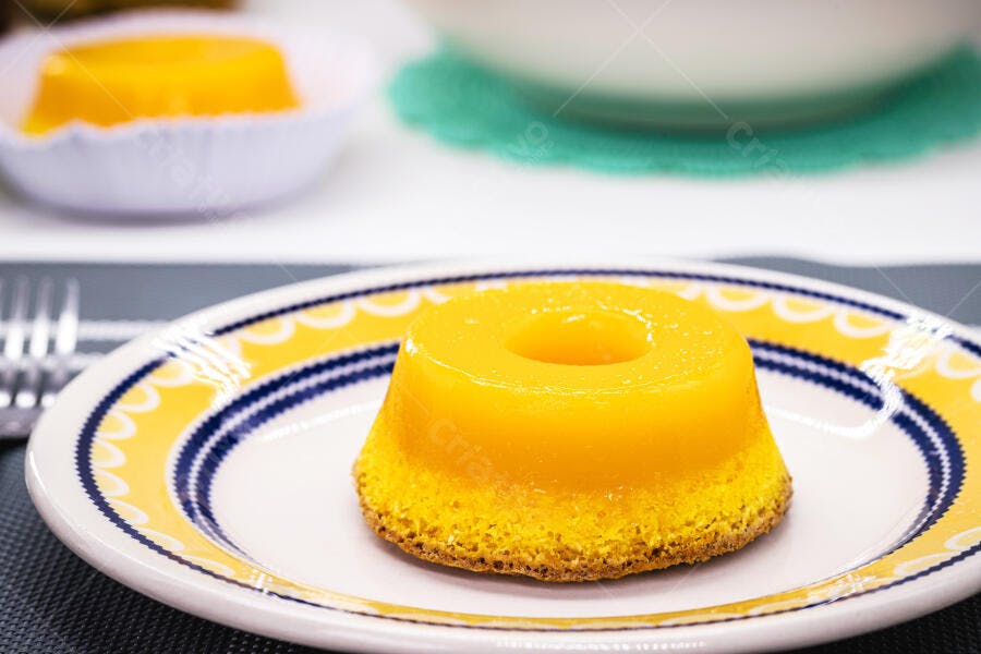 Quindim tradicional amarelo em prato decorado azul e amarelo