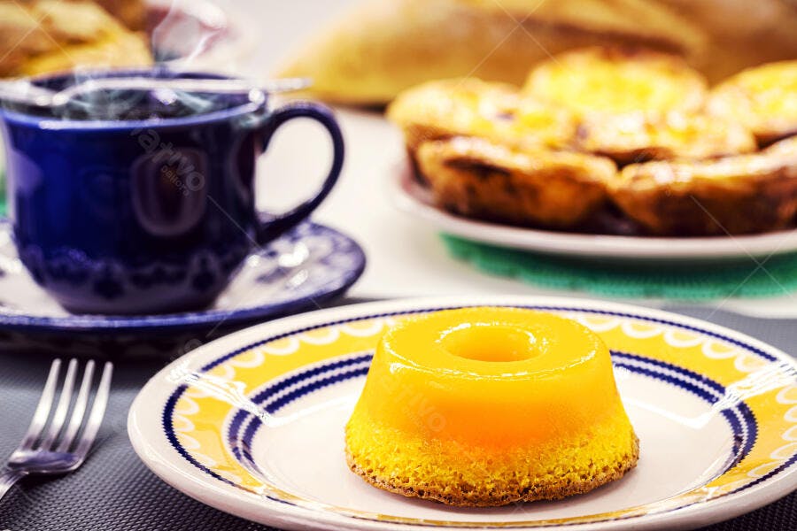 Pudim amarelo cremoso com café fumegante e pastéis de nata