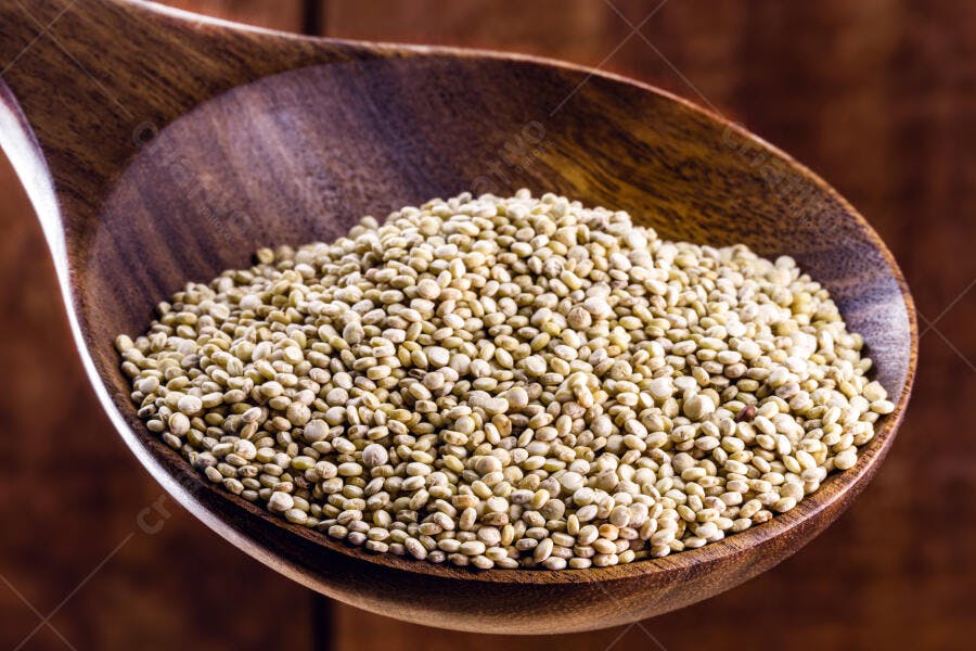Quinoa branca orgânica em colher de madeira rústica no close-up