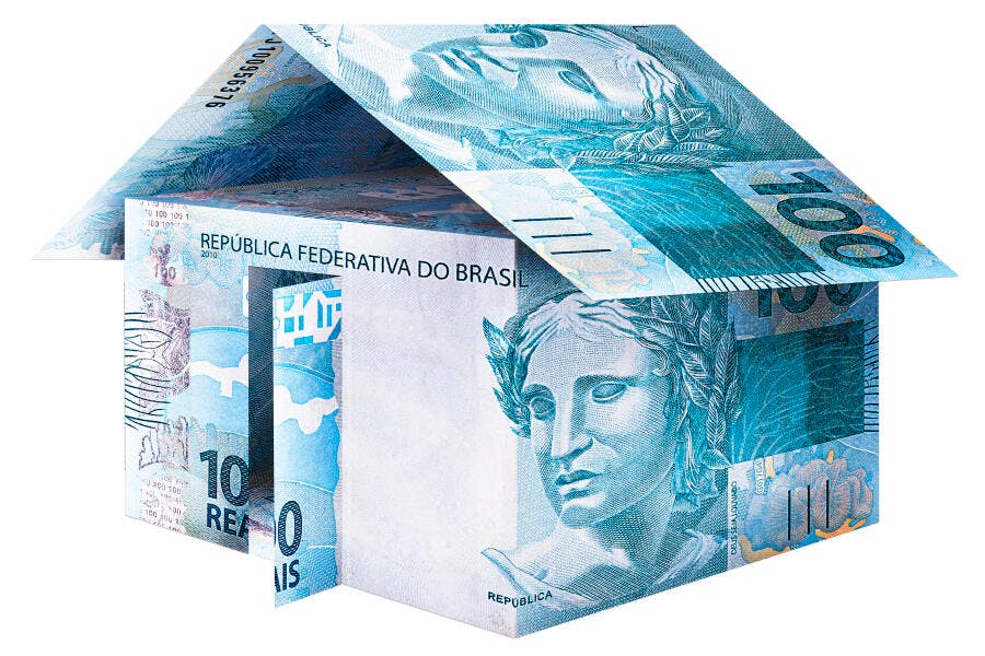 Casa feita com notas de Real brasileiro azul e verde simbolizando investimento imobiliário