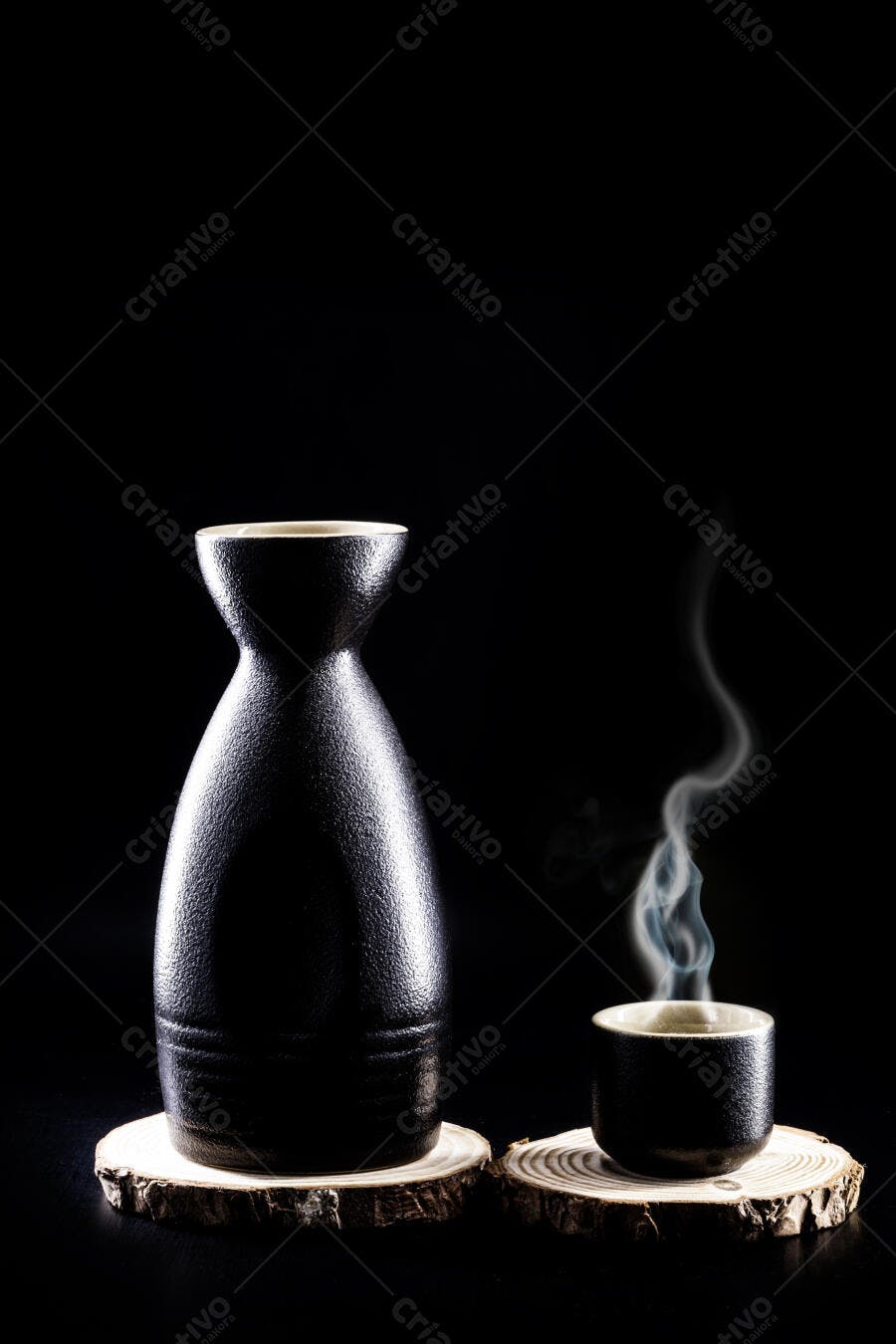 Saquê garrafa e copo cerâmica preta com vapor em base de madeira