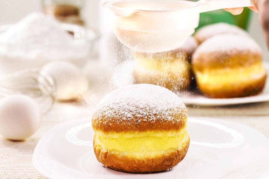 Donut doce recheado com creme amarelo polvilhado com açúcar
