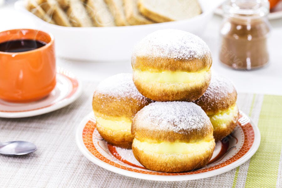 Sonhos recheados com creme e açúcar de confeiteiro café da manhã saboroso