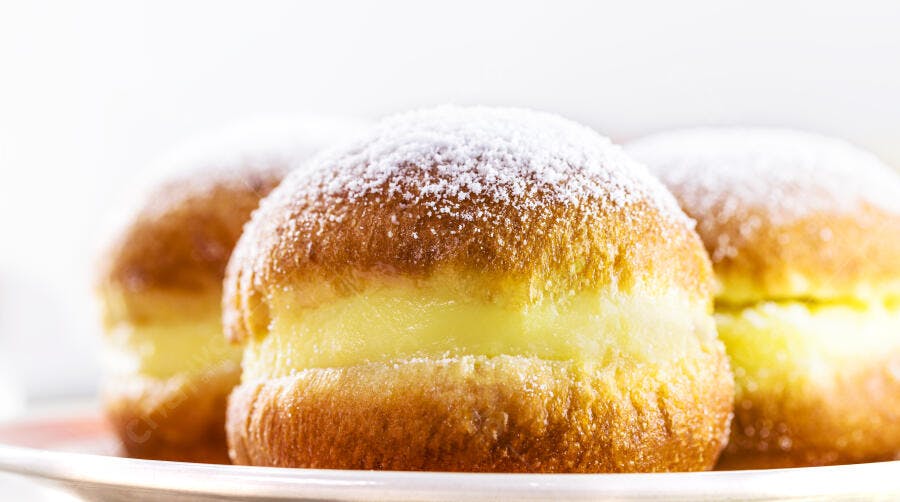 Sonhos recheados com creme e açúcar de confeiteiro em close-up