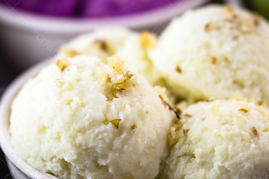 Sorvete de baunilha cremoso com nozes picadas em tigela branca