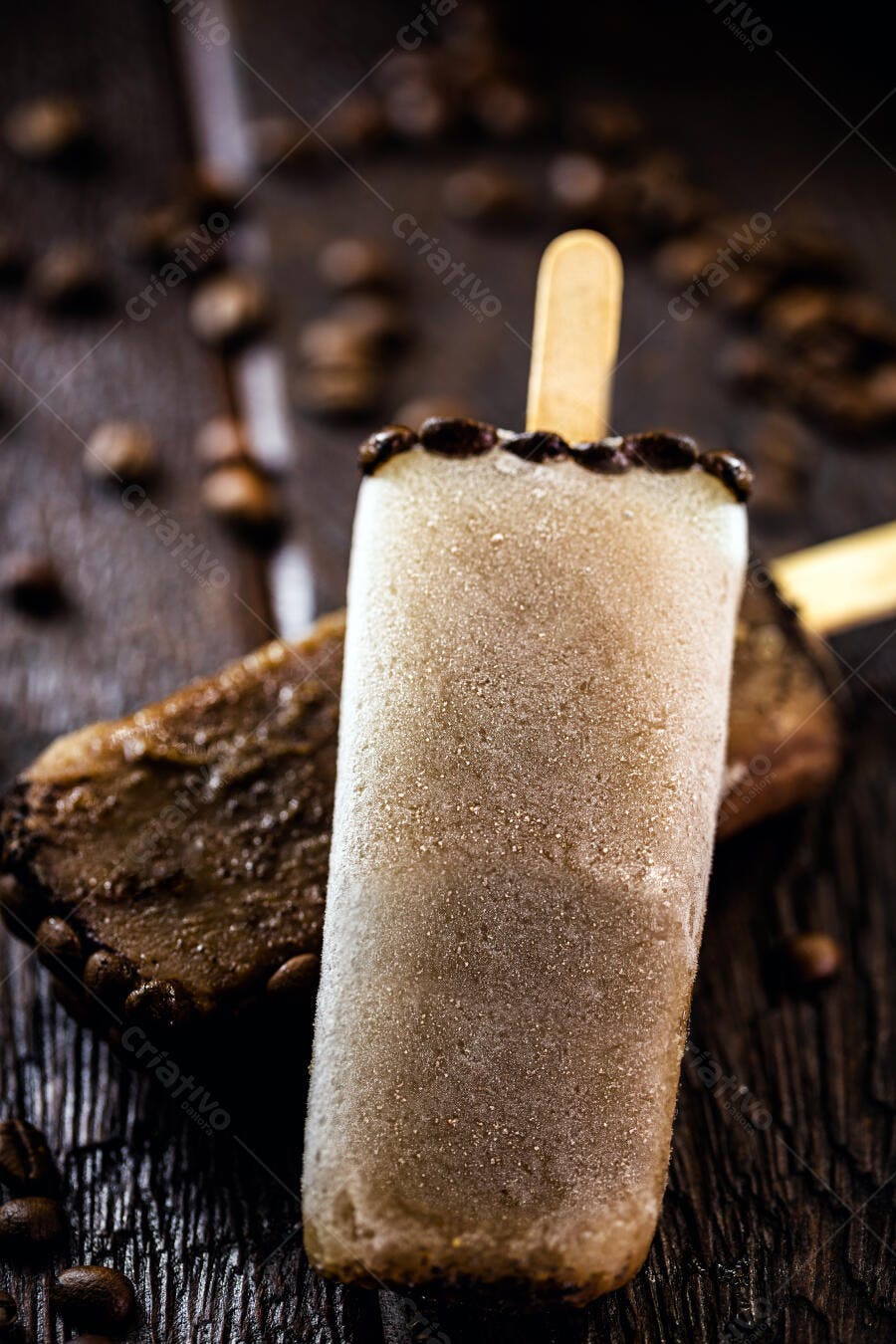 Picolé de café cremoso coberto de gelo sobre madeira rústica e grãos de café