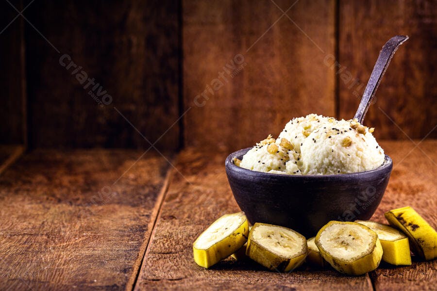 Sorvete de banana caseiro em tigela rústica com fatias de fruta na madeira