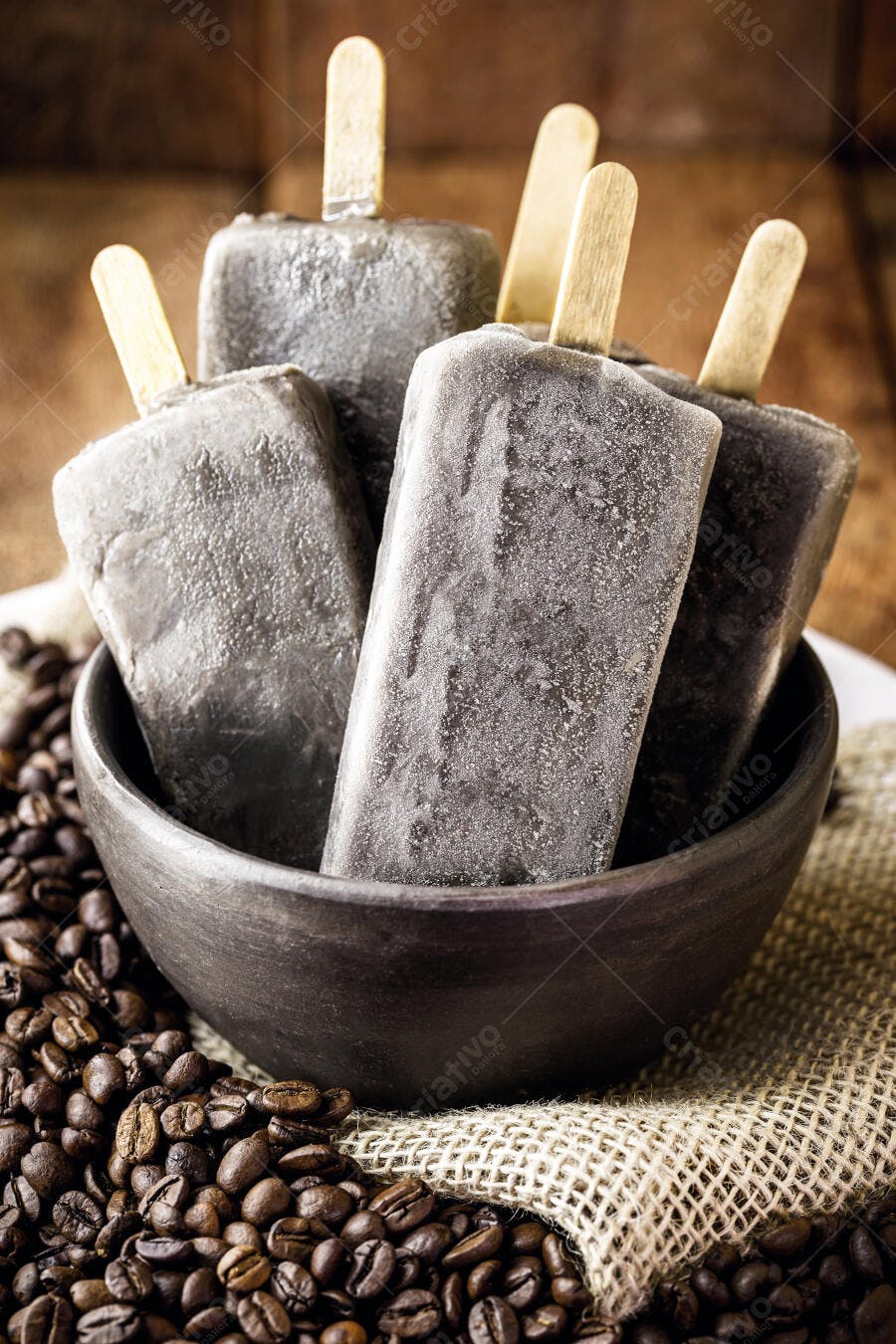 Picolés de café gelados em tigela rústica com grãos de café ao redor