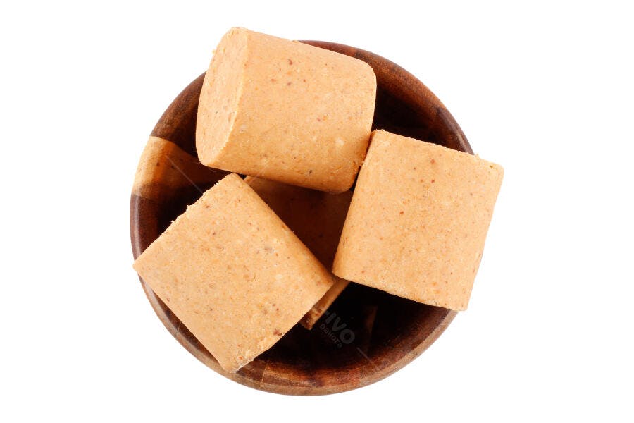 Paçoca doce de amendoim tradicional brasileiro em tigela de madeira fundo branco