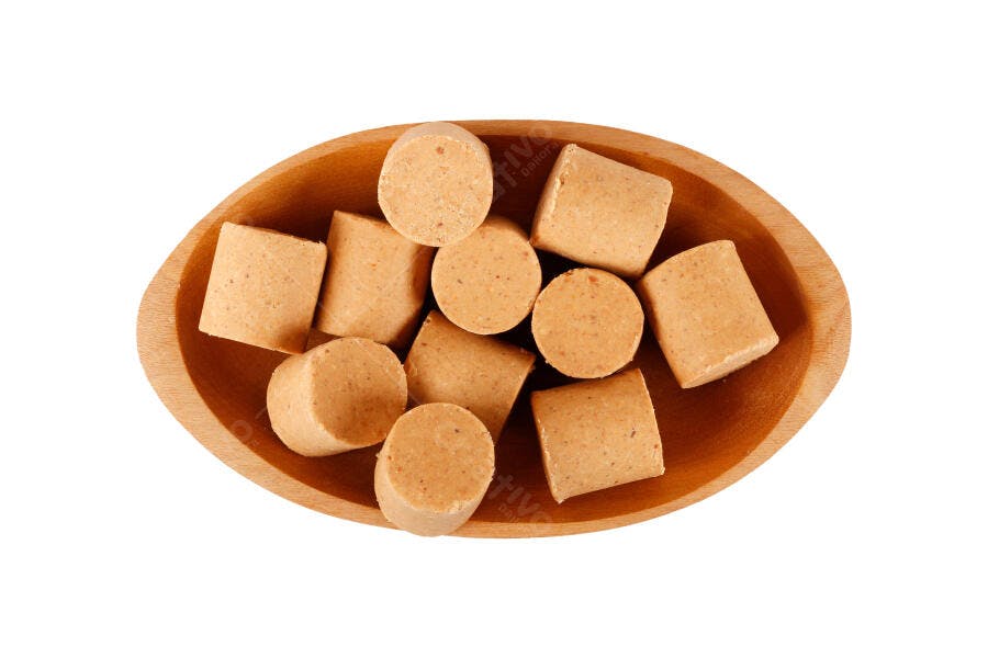 Paçoca doce de amendoim em tigela de madeira clara