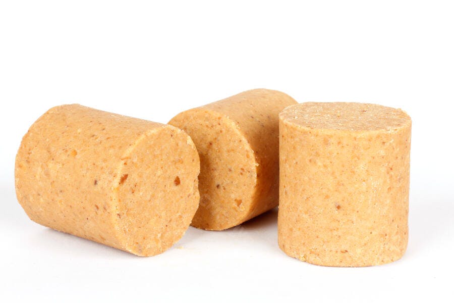 Três paçocas doces de amendoim sobre fundo branco