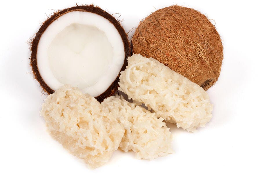 Coco fresco e cocadas doces pedaços em fundo branco