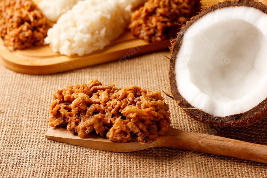 Cocada de coco marrom e branca doce artesanal em mesa rústica