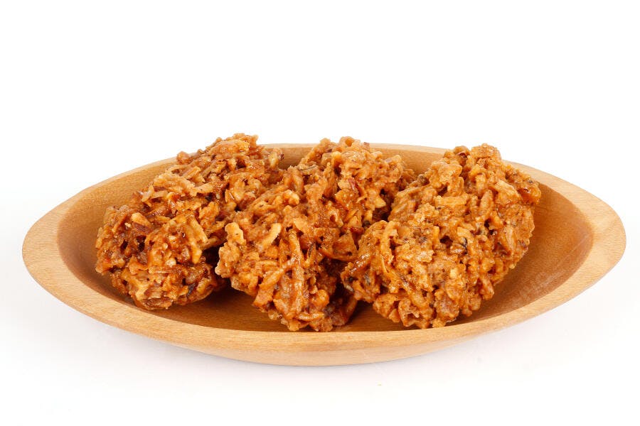 Cocada brasileira de coco caramelizado em travessa de madeira clara
