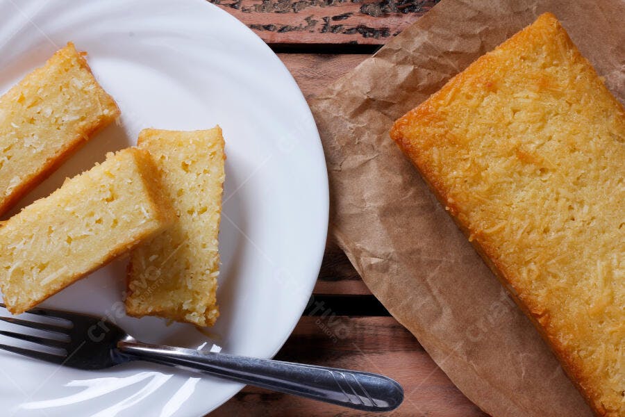 Bolo de coco fresco fatiado em prato branco com garfo