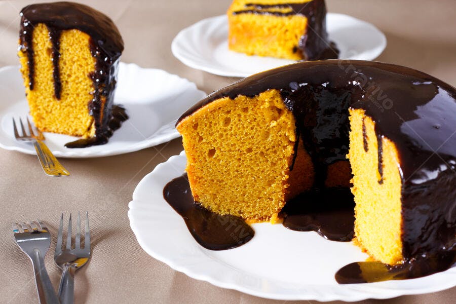 Bolo de cenoura com calda de chocolate em pratos brancos sobre a mesa