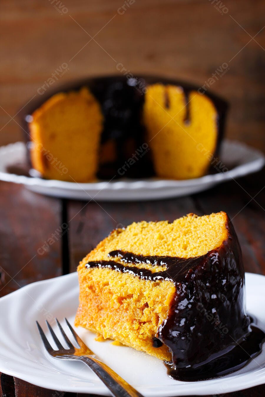Fatia de bolo de cenoura com calda de chocolate em prato branco