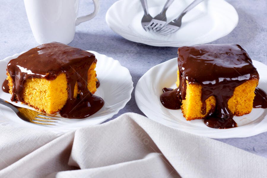 Bolo de cenoura com cobertura de chocolate em pratos brancos