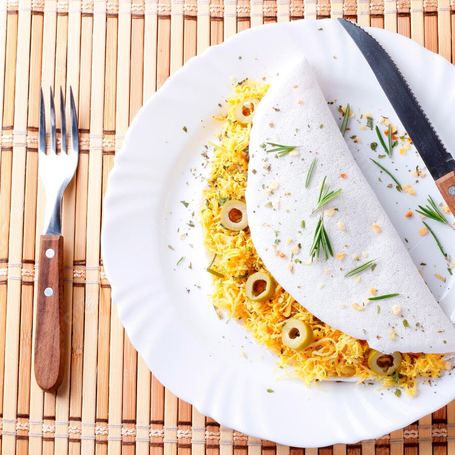 Tapioca recheada com frango desfiado e azeitonas em esteira de bambu