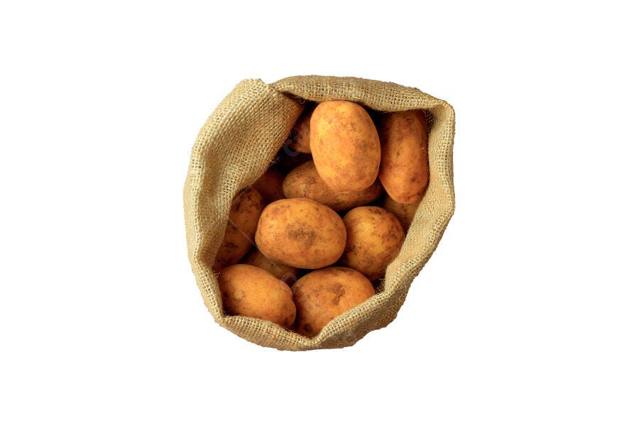 Batatas frescas em saco de estopa isoladas sobre fundo branco