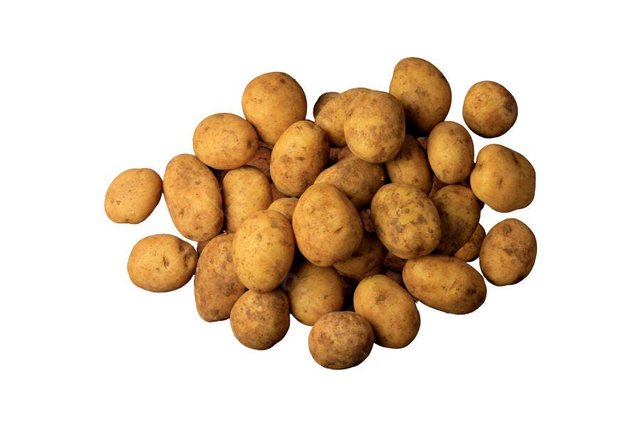 Batatas frescas amareladas empilhadas em fundo branco